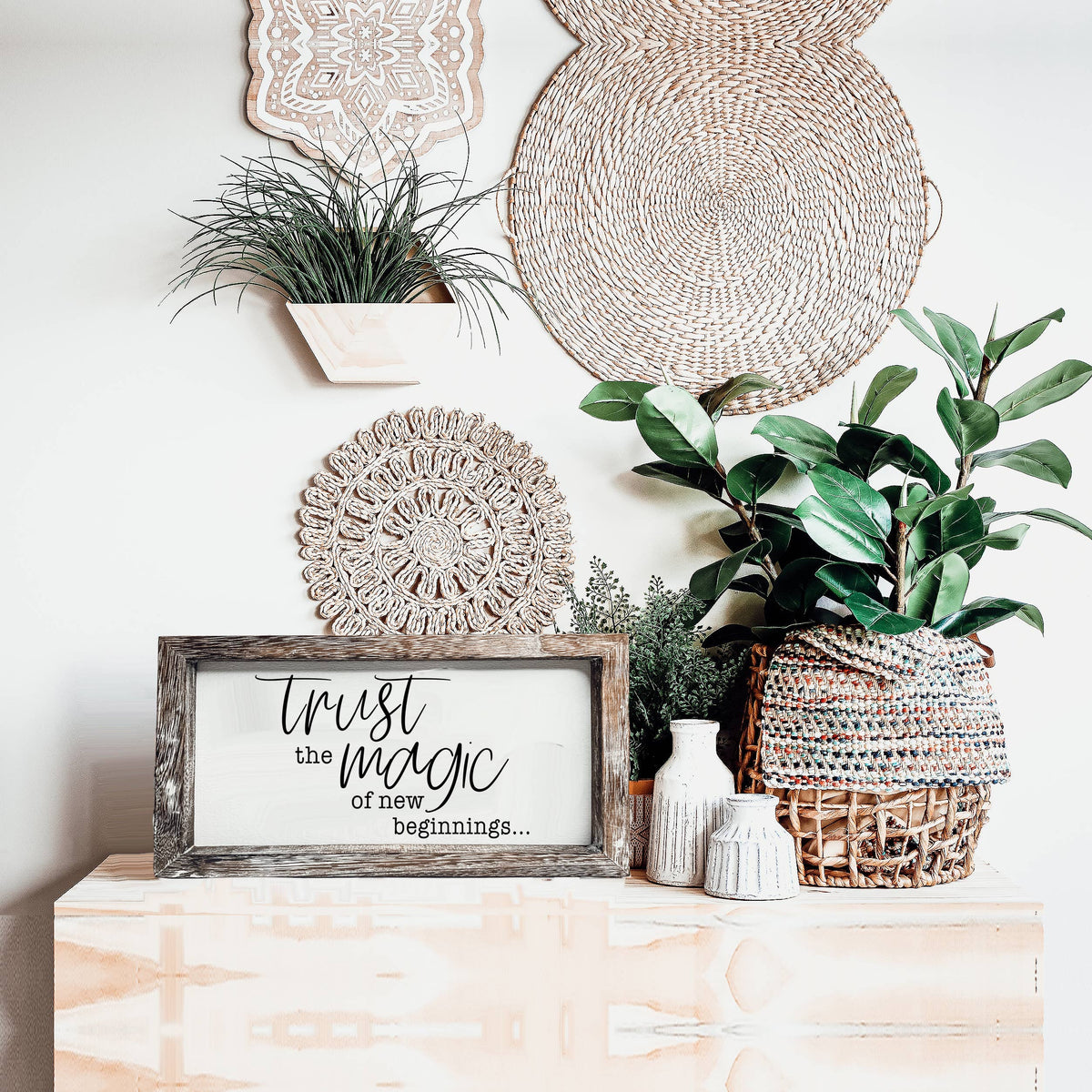 Trust Magic wooden sign displayed with woven decor and potted plants.